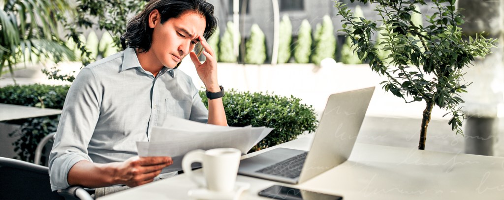 Man reviewing paperwork trying to make a decision