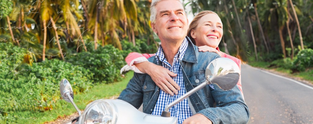 Couple riding a scooter through a tropical road